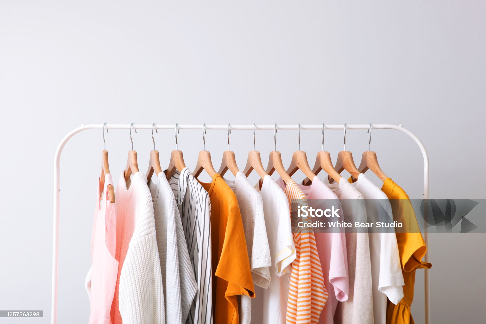 fashion clothes on a rack in a light background indoors. place for text