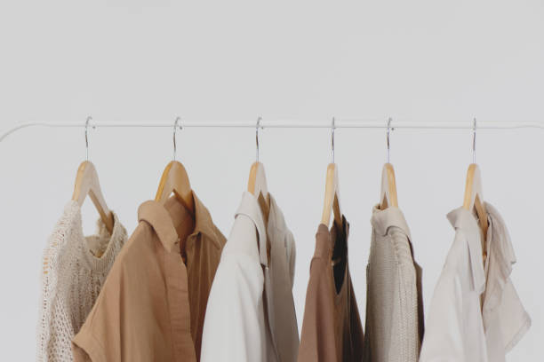 Collection of female clothes hanging on a rack on white background